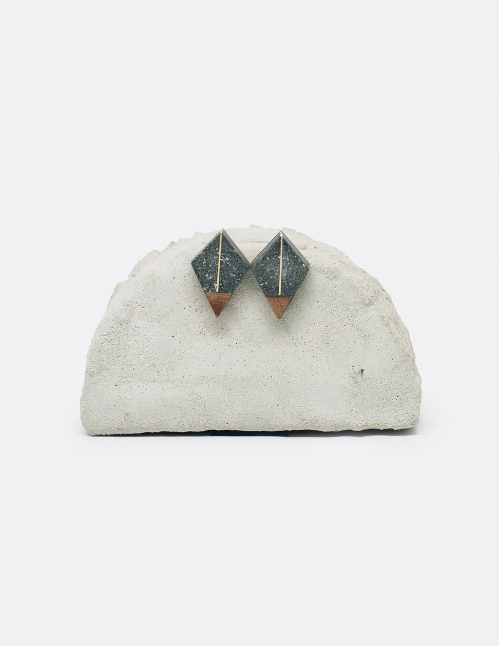 Yomo Studio line to triangle earrings. Materials include: concrete, brass, and walnut wood.